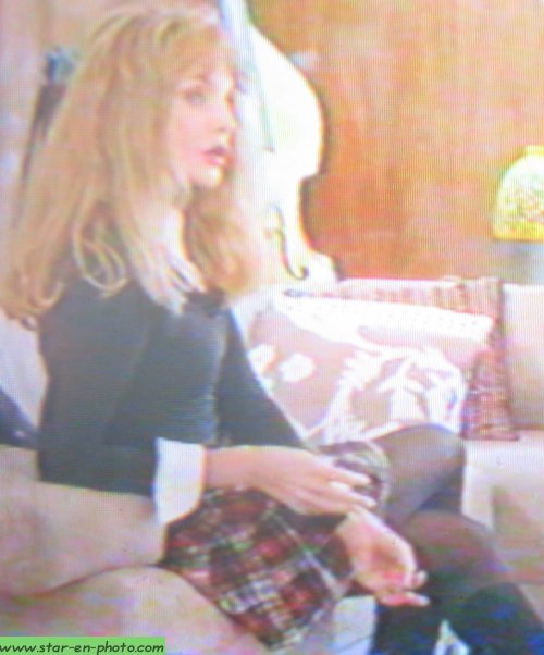 Arielle Dombasle assise se questionne