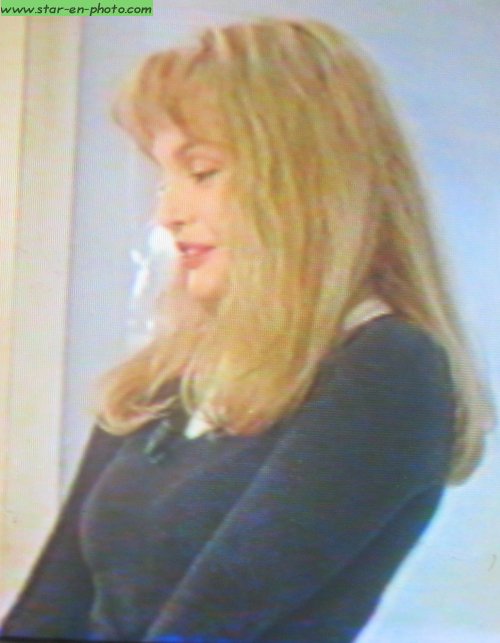 Arielle Dombasle assise se questionne